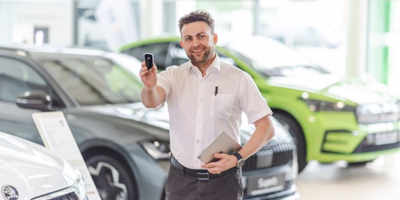 In unserem Autohaus in Scheibbs bieten wir ab sofort eine berufliche Chance als Automobilverkäufer - gleich jetzt bewerben! Am Bild: Verkäufer, welcher einen Autoschlüssel in die Höhe hält