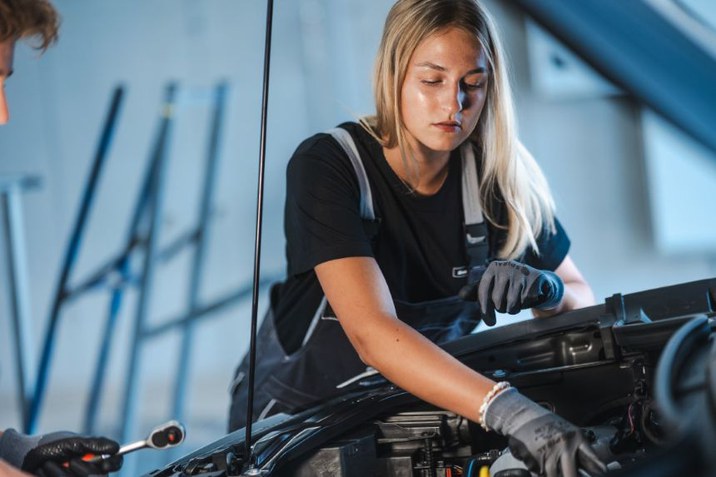 Für alle Modelle älter als 4 Jahre der Marken VW, VW Nutzfahrzeuge und Audi erhalten Sie bei uns vielfältige Service- und Wartungsangebote. Mechaniker schaut in Motorraum von Fahrzeug.
